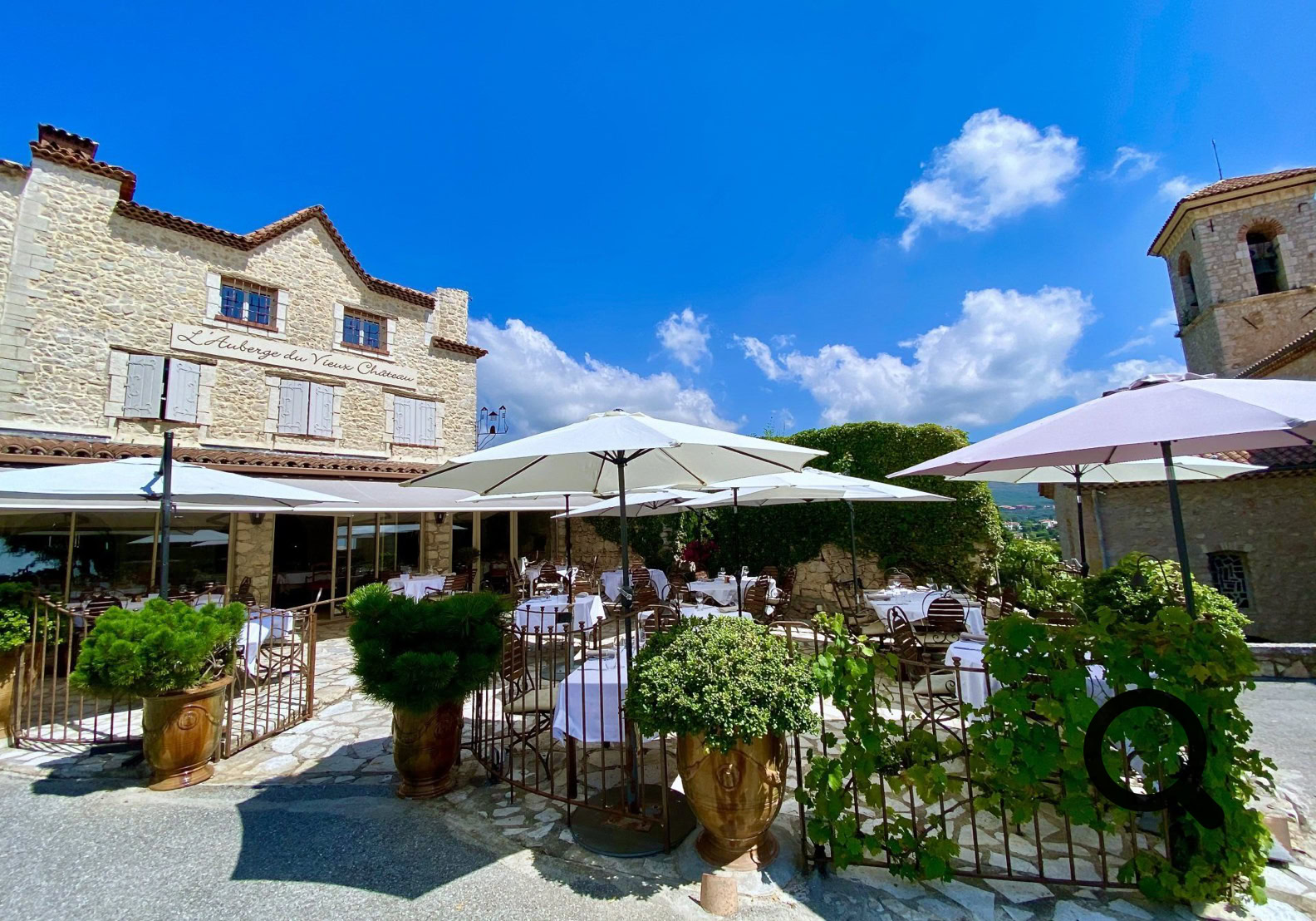 Située sur la Place Mirabeau, cette auberge offre une vue panoramique à 360° sur la Côte d’Azur et le bassin méditerranéen. Le décor conjugue pierres d’antan, sols en pierre de Bourgogne, vaste cheminée d’époque et véranda lumineuse, pour une ambiance alliant histoire, chaleur provençale et élégance.  Dirigée par le chef Tim Cinquin, sa cuisine met en avant des produits de saison et de terroir, alternant terre et mer.  Parfait pour les fins gourmets en quête d’un cadre historique, d’une cuisine provençale raffinée et d’une vue époustouflante — idéale pour un déjeuner ou dîner mémorable à Cabris.