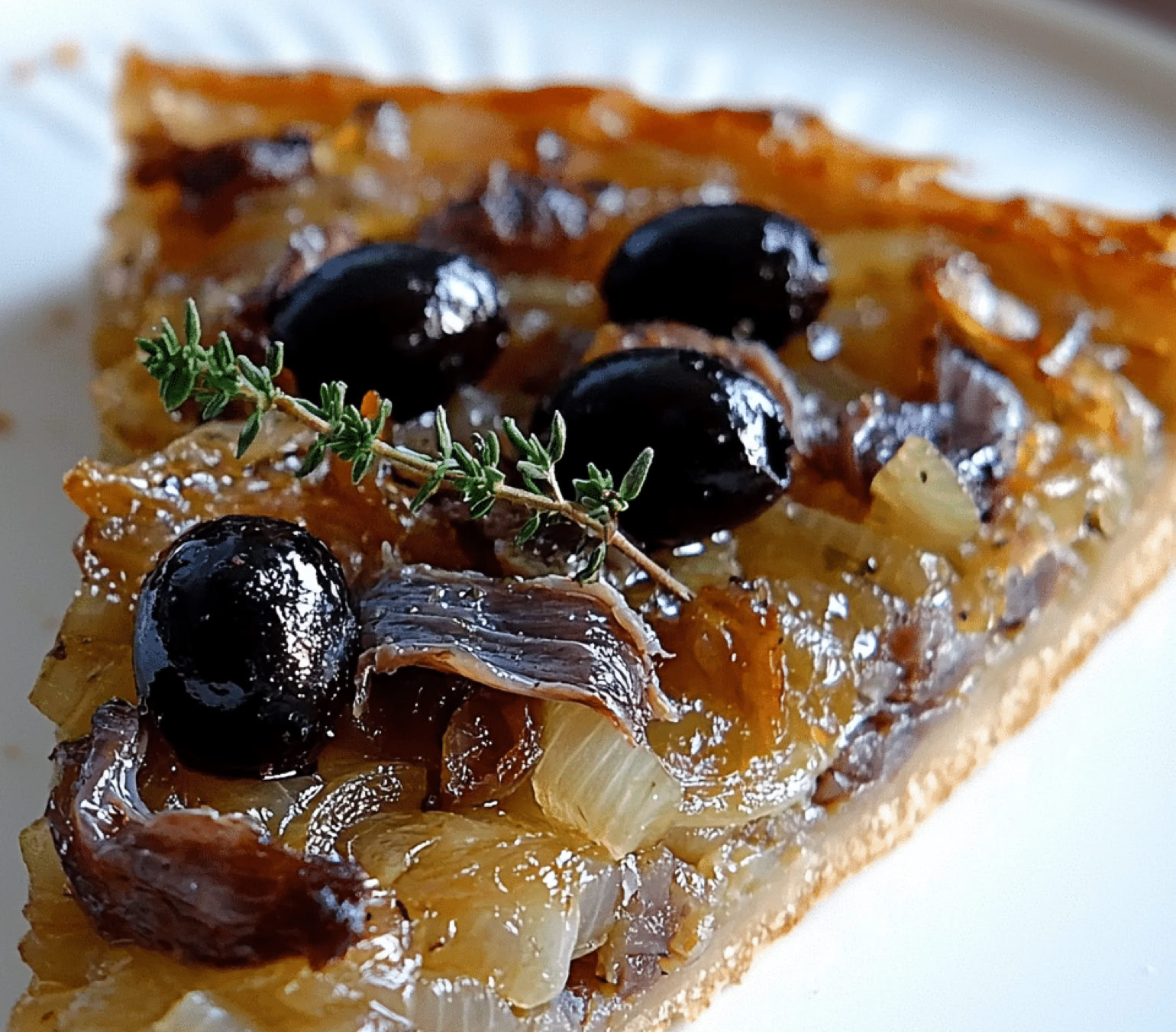 Another iconic specialty from the Nice region, and also widely enjoyed throughout Provence. It’s a kind of savory tart, somewhat similar to pizza, but with its own distinct character. It’s made with a bread dough or pizza dough base, generously topped with a sweet onion compote—slowly caramelized—along with anchovy fillets and black olives.