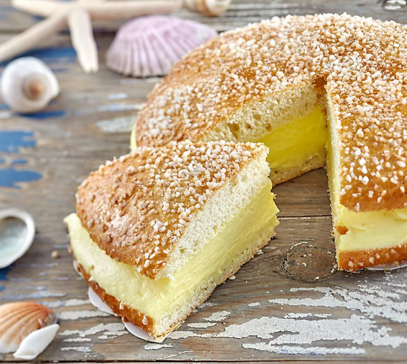 Créée dans les années 1950 à Saint-Tropez, la tarte tropézienne est une brioche moelleuse saupoudrée de sucre grain et garnie d'une crème légère mêlant crème pâtissière et crème au beurre.