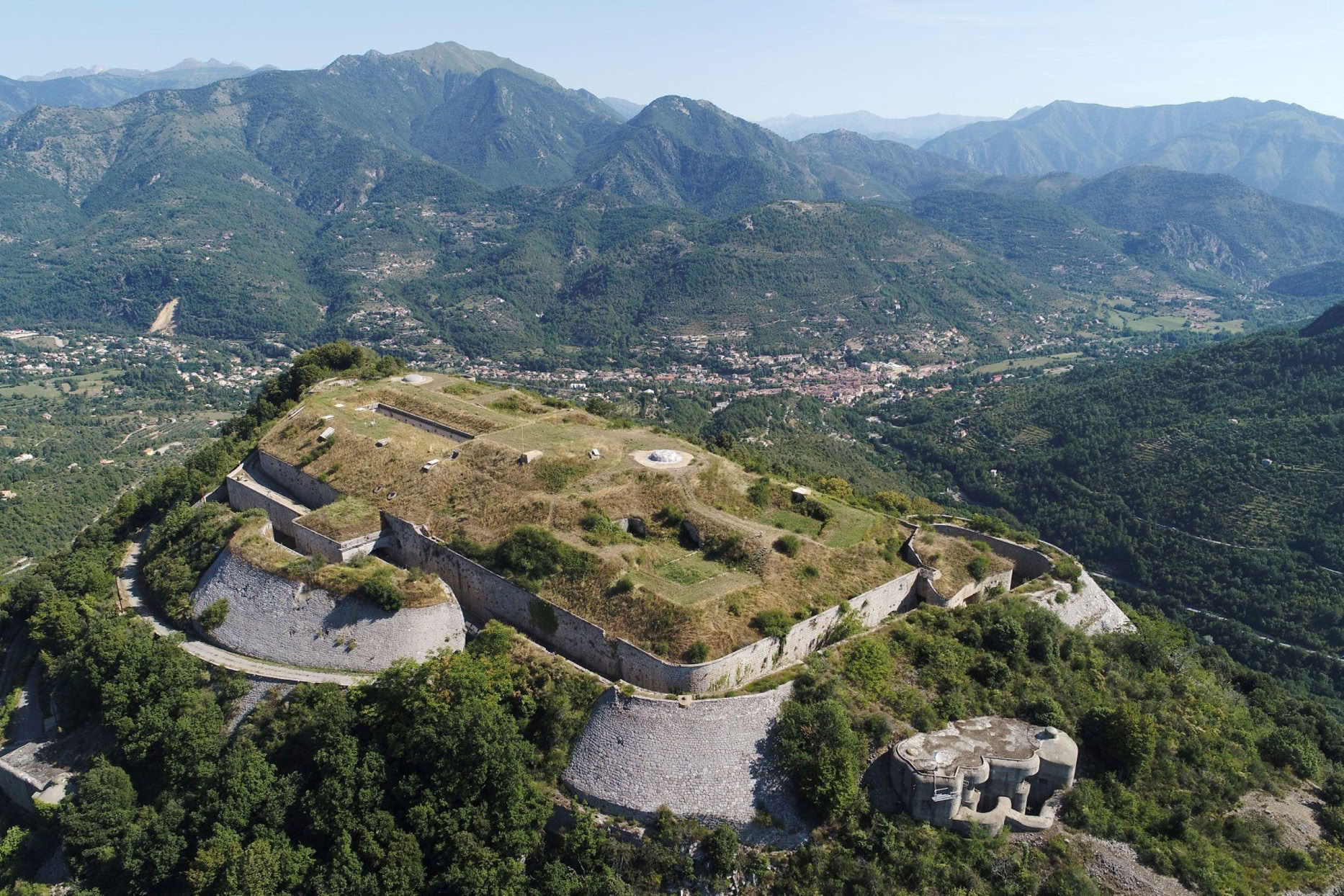 Perched at nearly 850 metres above sea level on a rocky spur, it enjoys an exceptional strategic position. From its heights, the view extends over the entire Bévéra Valley, the roads leading from Italy, and the surrounding mountains.  It is easy to understand why this site was chosen to defend the access routes to Nice.
