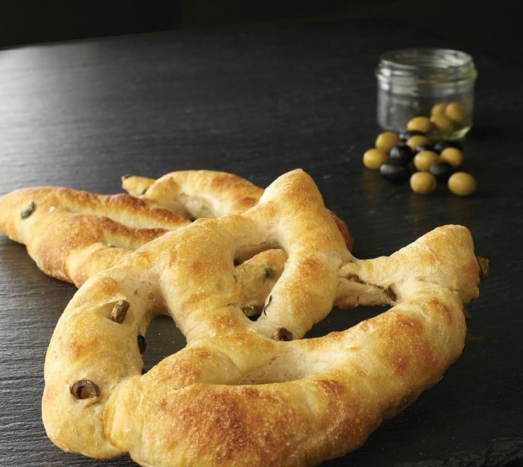 La fougasse est un pain traditionnel provençal reconnaissable à sa forme allongée et ajourée, rappelant un épi de blé ou une feuille.