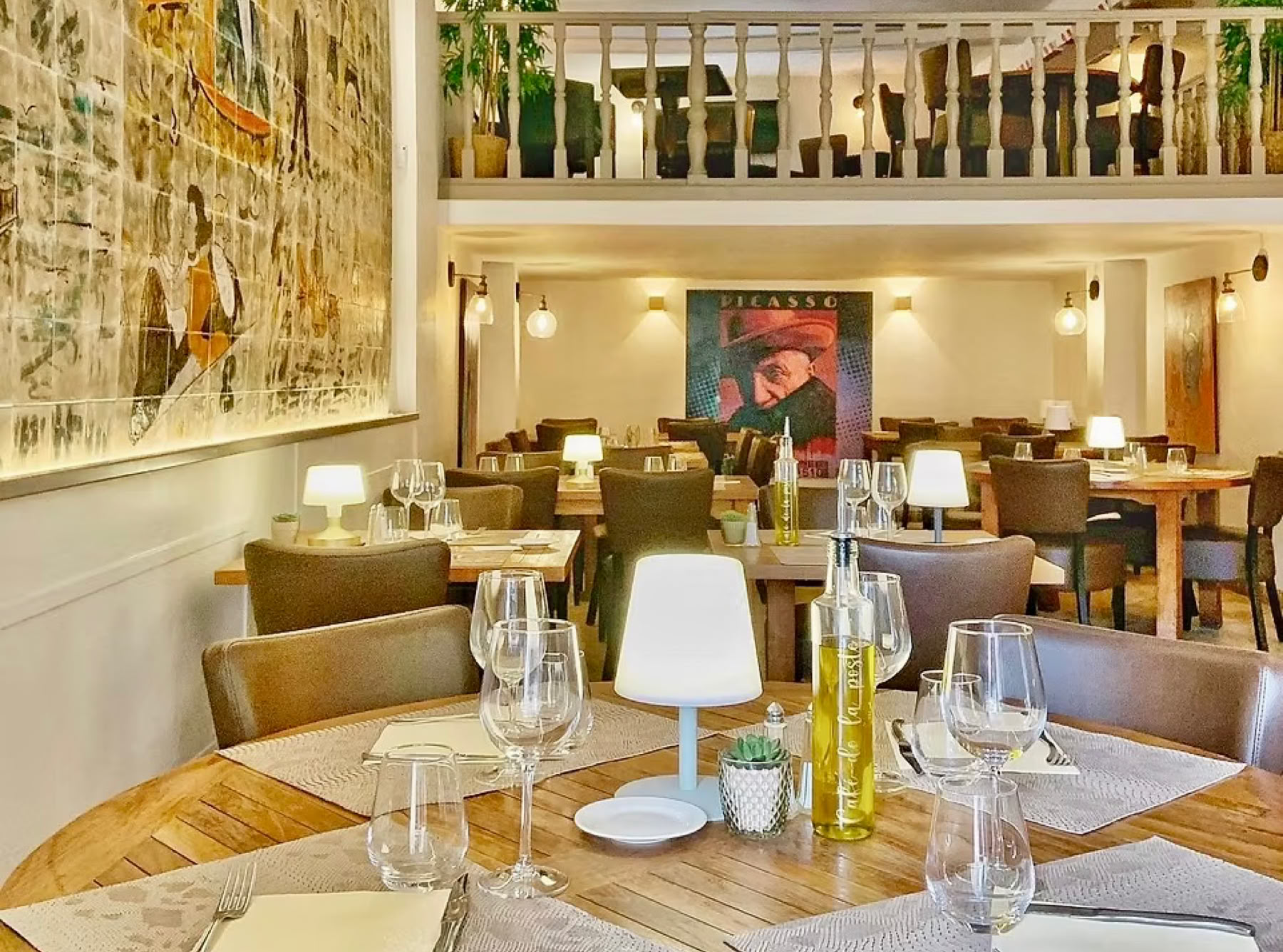 Le Café de la Poste, situé en plein cœur du village de Biot, est une véritable institution locale depuis 1885.  Façade d’époque, terrasse ombragée sous les platanes autour de la fontaine, et intérieur cosy avec mezzanine, fresque en faïence, poutres peintes et lustre coloré – une atmosphère chaleureuse et authentique.  C'est une étape incontournable pour ceux qui recherchent un bistro provençal typique, avec un cadre charmant et une cuisine méditerranéenne de qualité à des prix vraiment raisonnables.