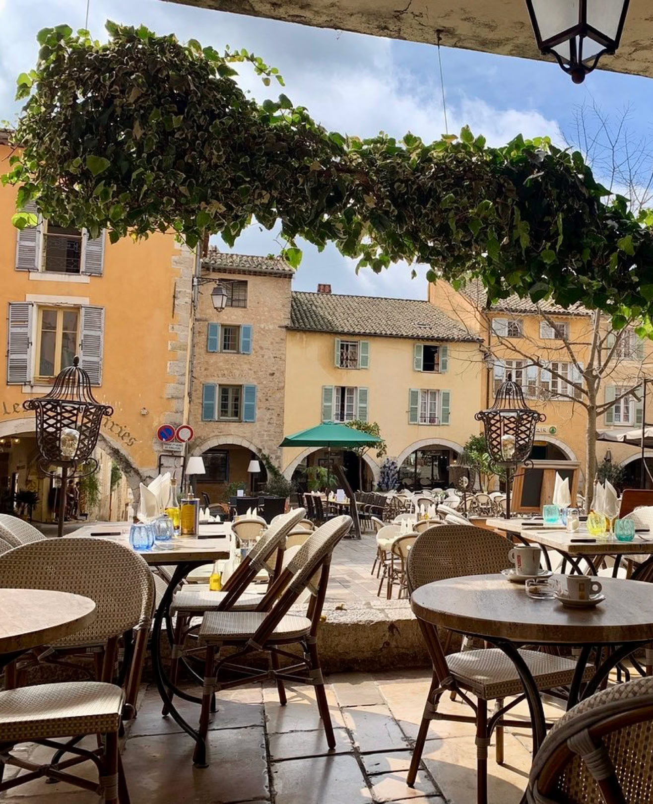 C'est une véritable institution de Valbonne, situé sous les arcades de la place centrale animée du vieux village.  On y déguste une cuisine simple, généreuse et locale dans une atmosphère détendue, avec le charme inimitable des terrasses provençales. C’est l’endroit parfait pour s’imprégner de l’ambiance du village, autour d’un verre ou d’un bon repas en toute simplicité.